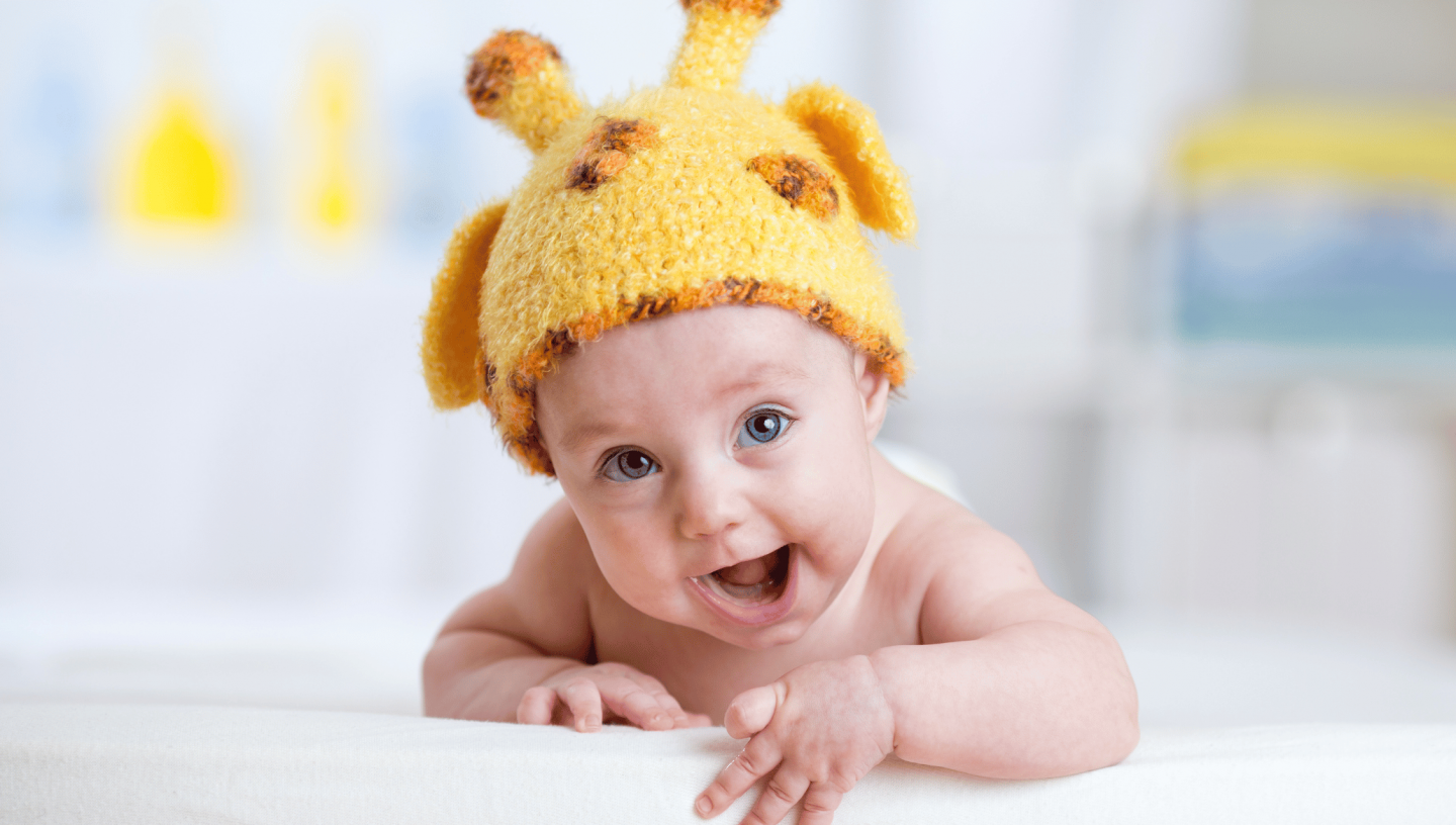 Month by month Teething Guide baby in giraffe costume